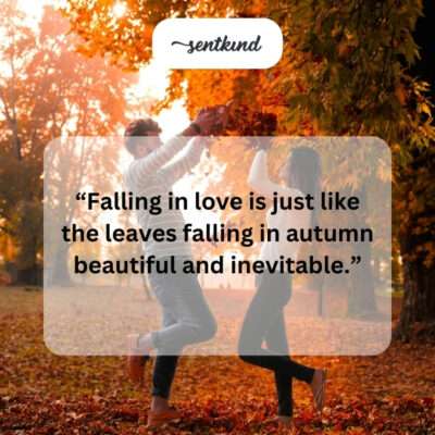 Couple holding hands surrounded by fallen leaves.