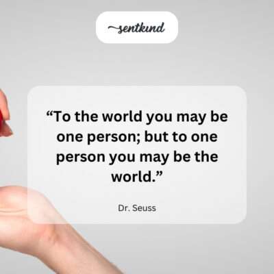 A small figure held lovingly in large hands against a vast world.