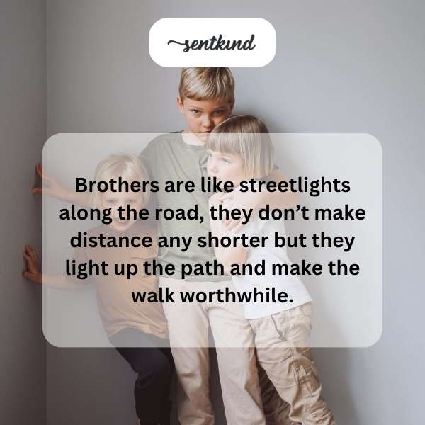 Two brothers are walking together down a brightly lit urban street at night.