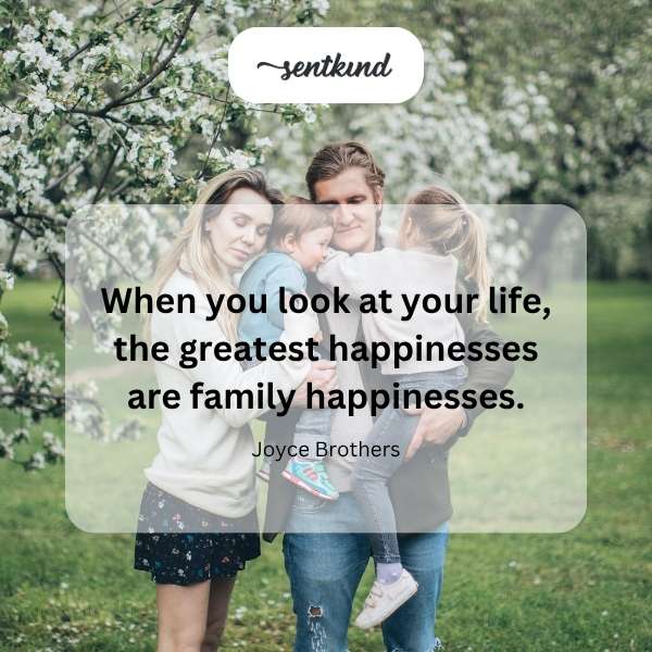 A multigenerational family gathers together, smiling and embracing.