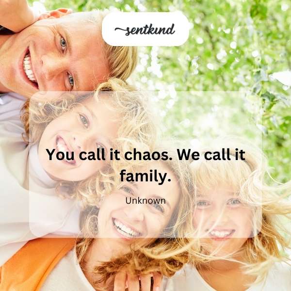 A group of diverse people are gathered together, smiling and interacting warmly, suggesting a close-knit and slightly unconventional family dynamic.