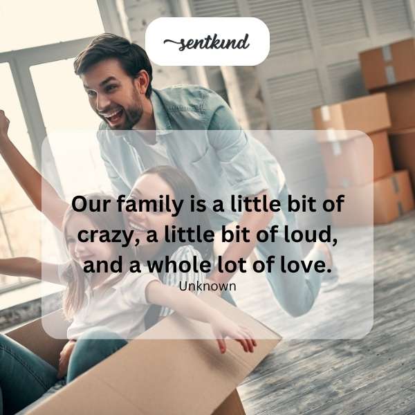 A diverse family group laughing and embracing in a warmly lit living room.