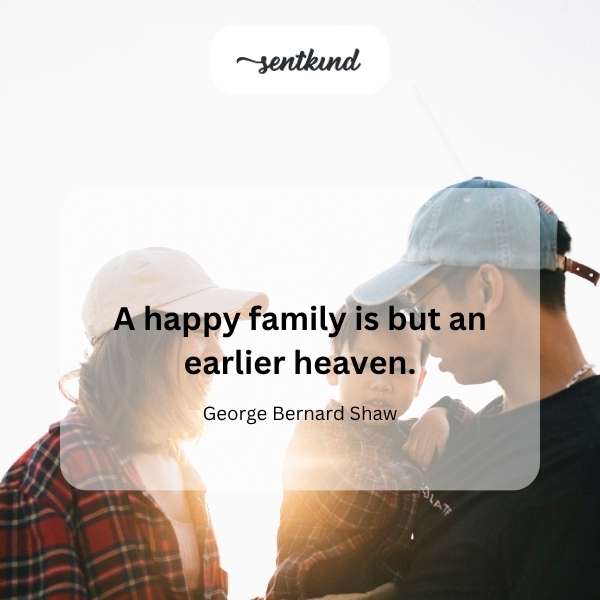 A smiling family of four is walking hand-in-hand through a sunlit park.