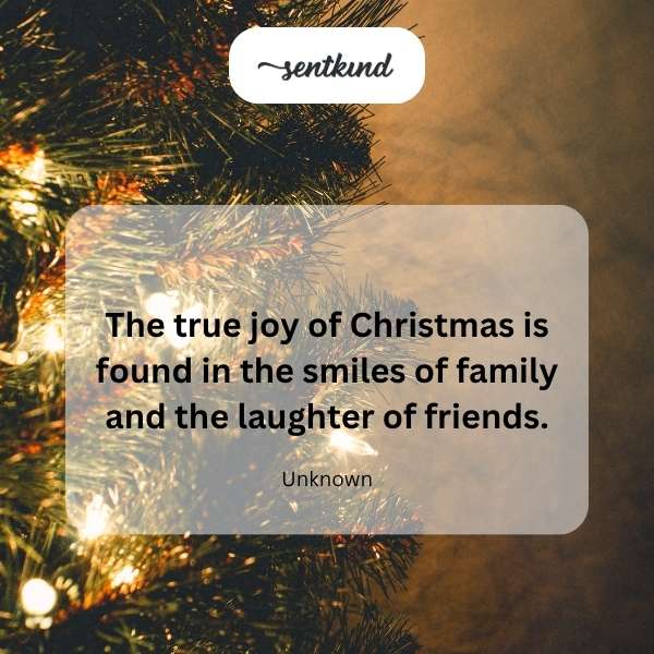 A group of diverse people are gathered around a festively decorated table, smiling and laughing.