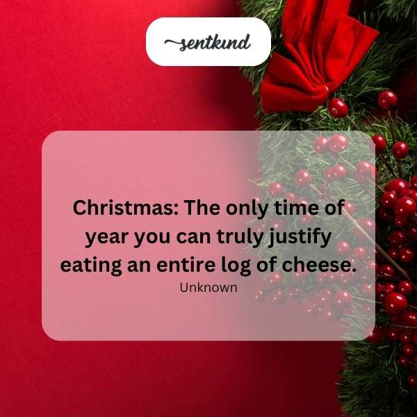 A cheese log decorated with festive Christmas garnishes, resting on a wooden cutting board.