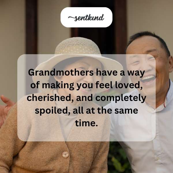 A smiling grandmother warmly hugs a child in a comfortable armchair, with cookies visible on a nearby table.