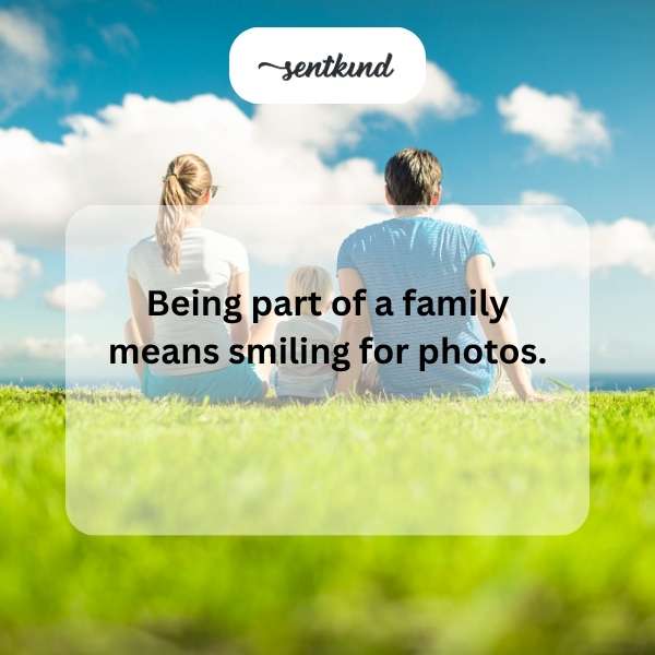 A diverse family is gathered around a quilted blanket made of colorful heart-shaped patches.