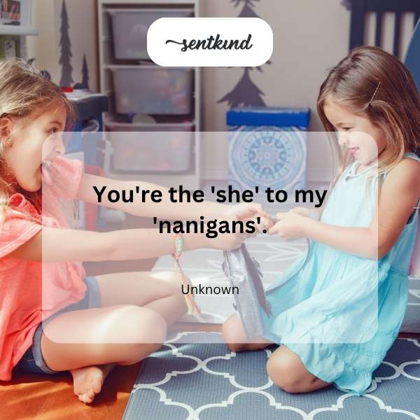 Two friends are laughing together and playfully bumping shoulders, sharing a mischievous look.