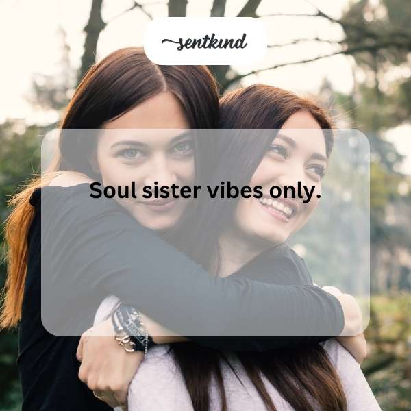 Two smiling young women are hugging tightly, radiating joy and deep connection.