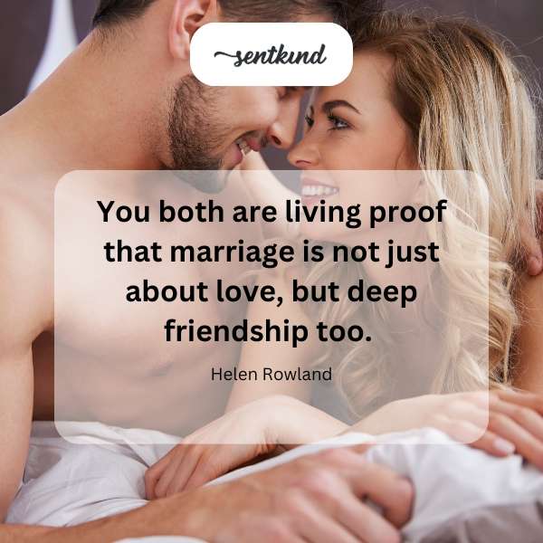 A loving couple laughing together while holding hands across a table.
