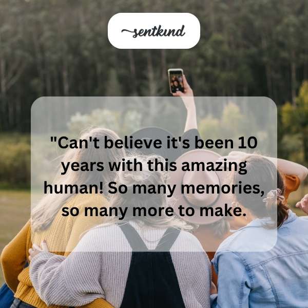 Two best friends are smiling while holding up a photo of themselves taken exactly ten years prior.