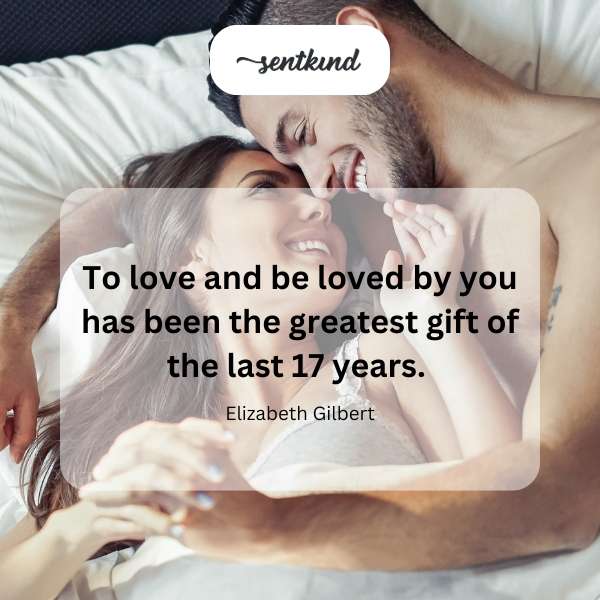 A couple embraces warmly in a sunlit, intimate setting.