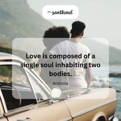 A couple stands side by side, holding hands and gazing into a sunset over a lake, symbolizing deep connection.
