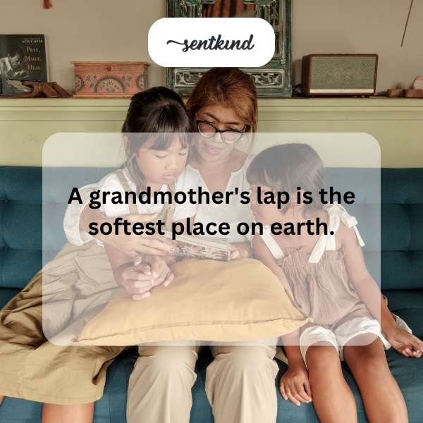A loving grandmother is seated in a comfortable chair, gently holding a small child asleep on her lap.