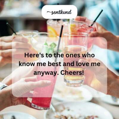 A diverse group of friends laughs together warmly while raising their glasses in a toast.
