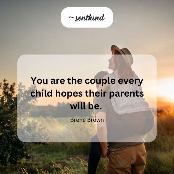 A smiling couple embraces warmly in a sunlit garden.
