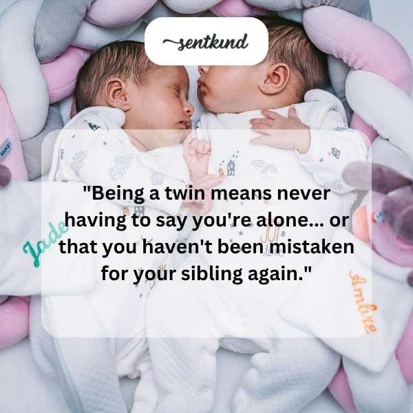 Two identical young women are smiling and standing side-by-side.