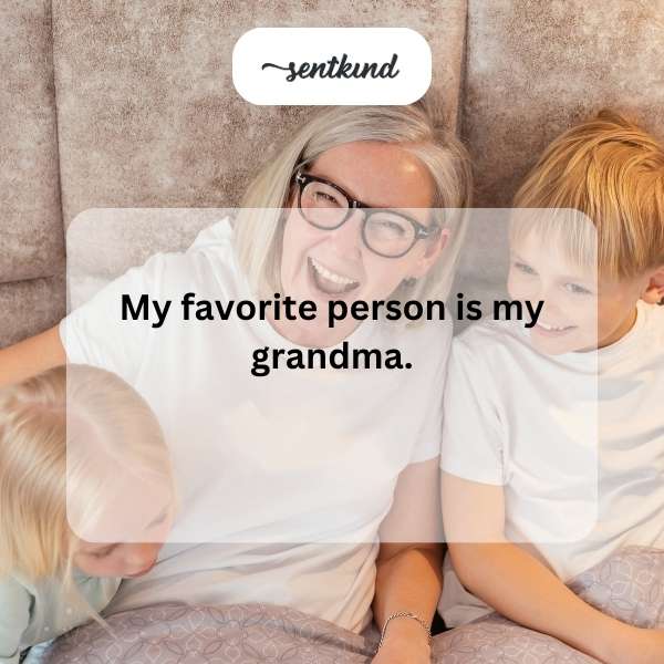 A smiling elderly woman is sitting on a park bench with a young person leaning their head on her shoulder.