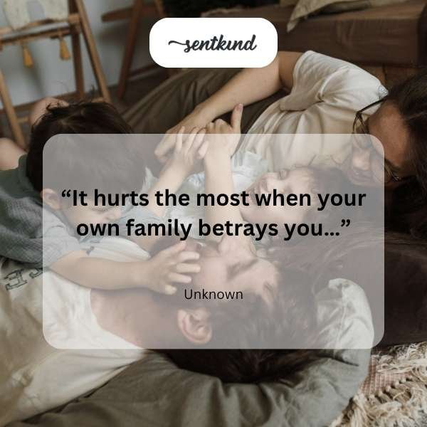 A solitary figure sits with their head in their hands, silhouetted against a window view suggesting distant figures, evoking feelings of pain and betrayal within a family context.