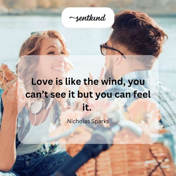 A person standing on a windy beach with hair blowing in the breeze.
