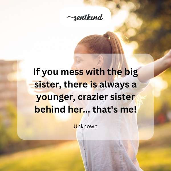 A younger sister with a mischievous smile stands slightly behind her older sister, who is looking forward with a protective expression.