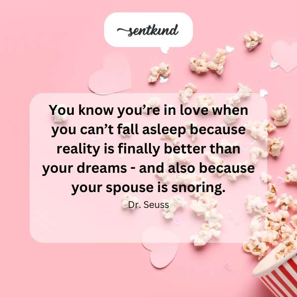 A couple is in bed, one asleep and snoring, the other awake and smiling.