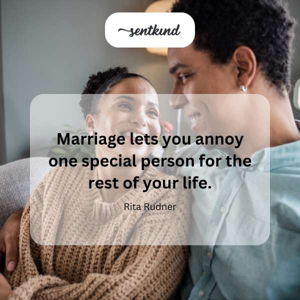A happy couple playfully teases each other while sitting on a park bench.