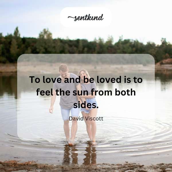 A couple embraces warmly under a vibrant sun.