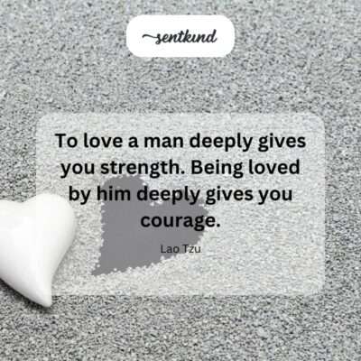 A man and woman stand together holding hands on a windswept cliff overlooking the ocean, symbolizing the strength and courage found in deep love.