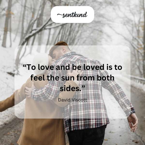 Two people embracing warmly in a sunlit meadow.