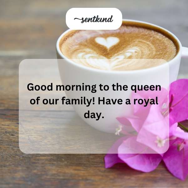 A woman, presumably a mother or grandmother, smiles while wearing a crown and holding a cup of tea.