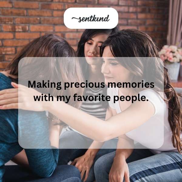 A diverse group of friends is sharing a laugh and hugging in a park during sunset.