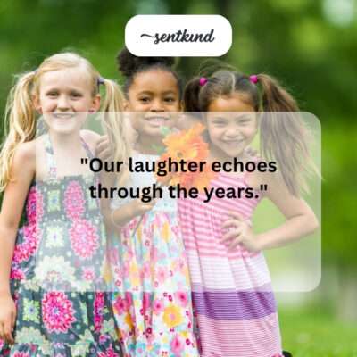 Two children sit together on a grassy hill, sharing secrets and giggling as they look out over a summer landscape.