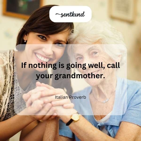 A young person is sitting on a couch, smiling as they talk on a smartphone, with a blurry background suggesting a cozy home environment.