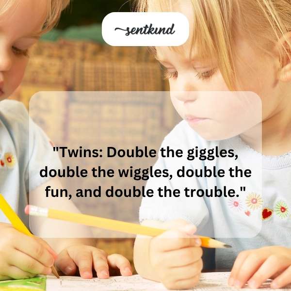 Two identical baby girls are sitting side-by-side, smiling at the camera.