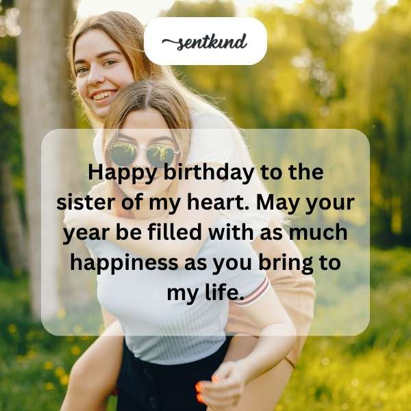 Two women who are close friends smiling warmly at each other during a birthday celebration.