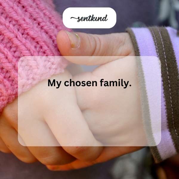 A diverse group of adults and children laugh and hug affectionately in a warm, supportive setting, embodying a chosen family.