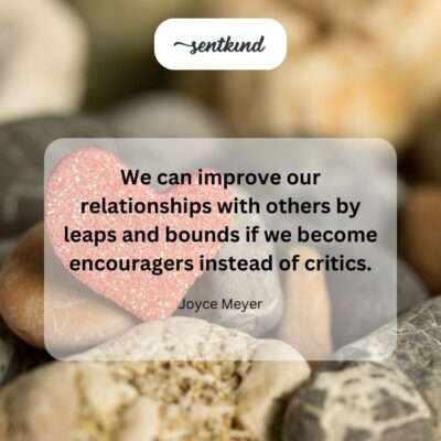 Two people are smiling warmly at each other while one offers a hand to the other, visually representing supportive and encouraging interaction.