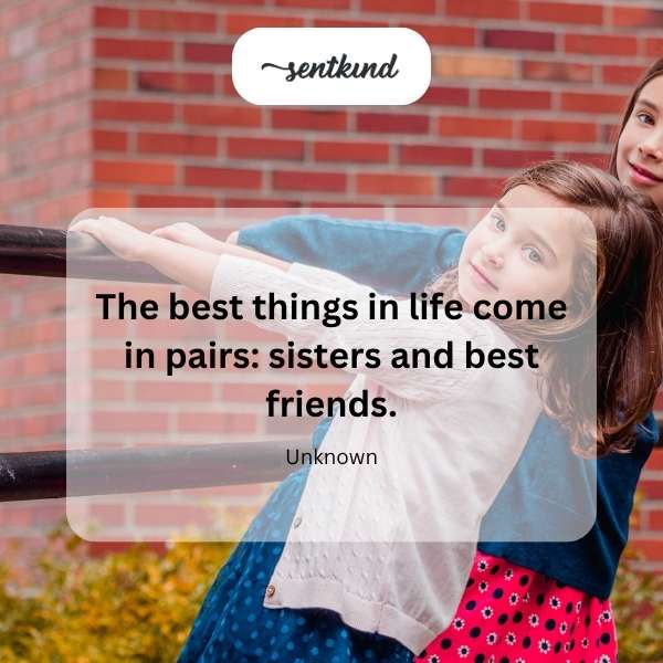 Two joyful young women, appearing to be sisters or best friends, are laughing and hugging each other outdoors in a sunlit park.