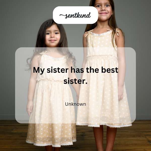 Two smiling sisters sharing a joyful embrace in a sunlit park, one looking proudly at the other.