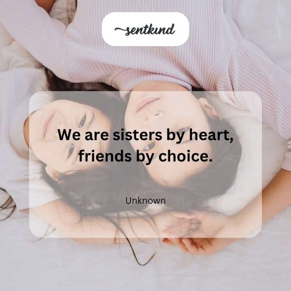 Two young women, embracing and laughing joyfully together outdoors, representing deep friendship and chosen sisterhood.