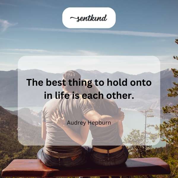 A loving couple embraces tightly, silhouetted against a warm sunset.