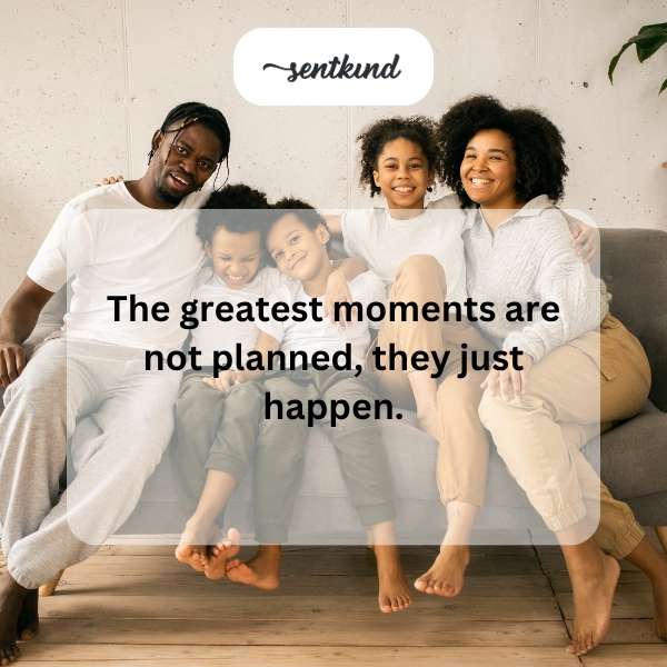 A group of diverse friends are laughing and smiling together on a mountaintop overlooking a scenic valley.