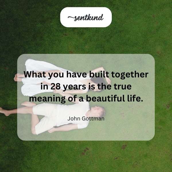 A mature couple is holding hands, smiling warmly at each other, surrounded by lush greenery.