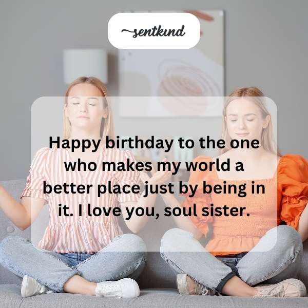 Two happy best friends hug tightly while holding cupcakes with lit candles during a birthday celebration.