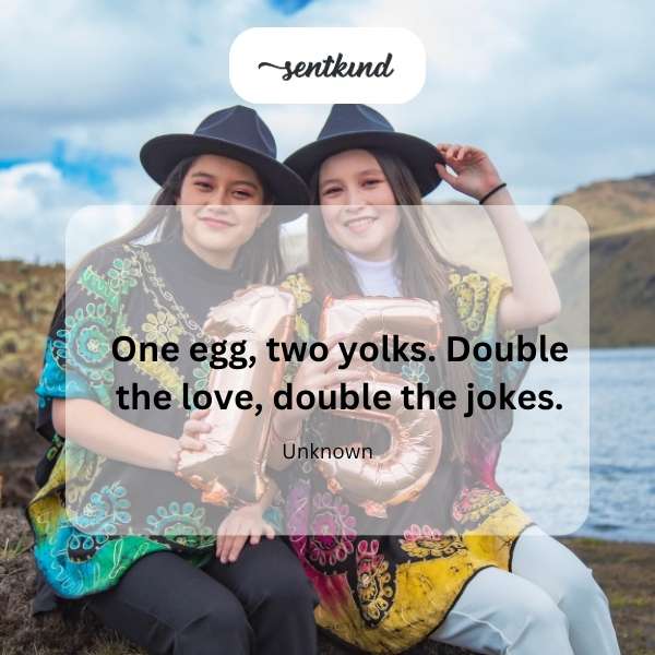 A cracked egg reveals two bright yellow yolks.