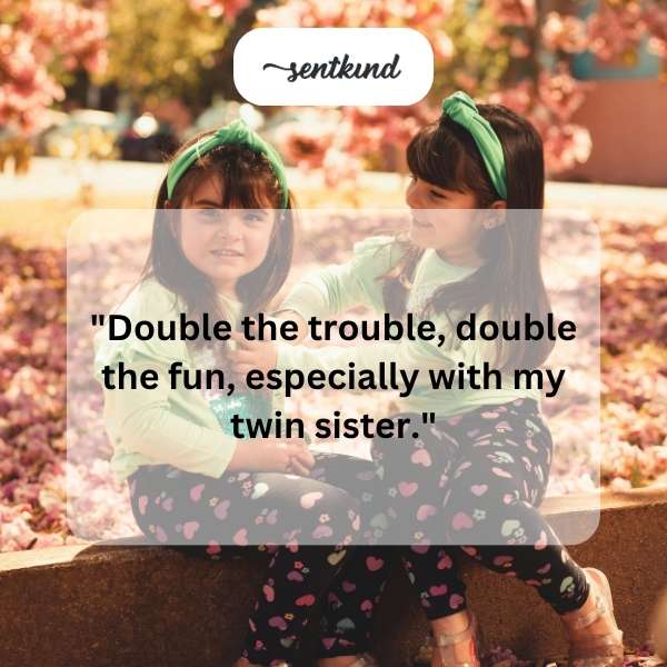 Two identical twin sisters are smiling and standing side-by-side.