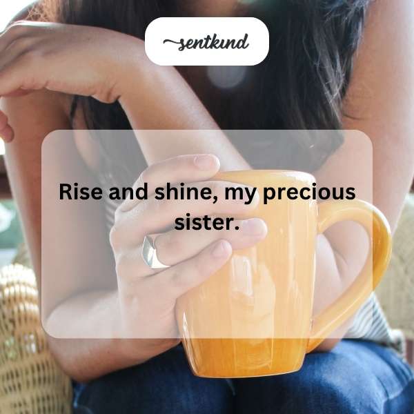 A younger sister gently wakes her older sister with a smile as morning light streams through the window.