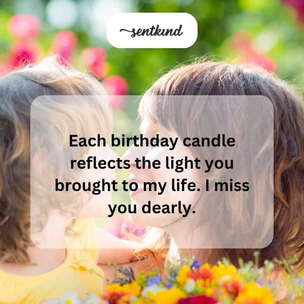 A lit candle beside a framed photo of a smiling mother.