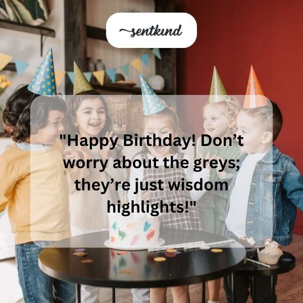 A person smiles warmly while holding a birthday cake with lit candles.